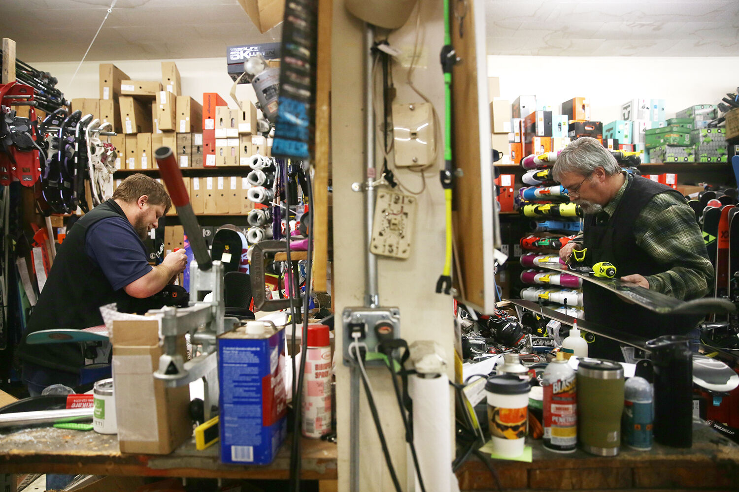 Luke Todd works on one pair of skis, right,